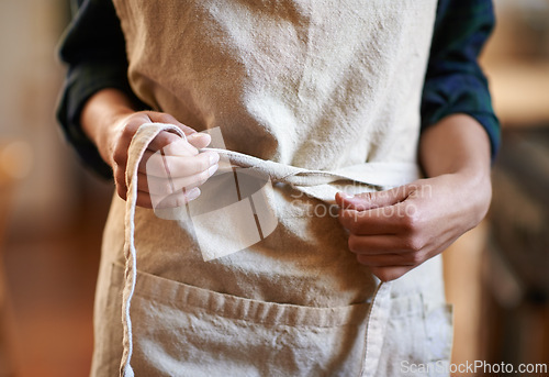 Image of Hands, chef and tie apron in kitchen, restaurant or catering service at hotel for gastronomy. Closeup, cooking or person with knot on clothes, culinary uniform or preparation of professional waitress