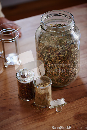 Image of Jar, tea leaves and herbal plant on kitchen counter or health benefits or morning beverage, refreshing or wellness. Bottle, vitality and prepare as hot drinking or jasmine, hibiscus or stress relief