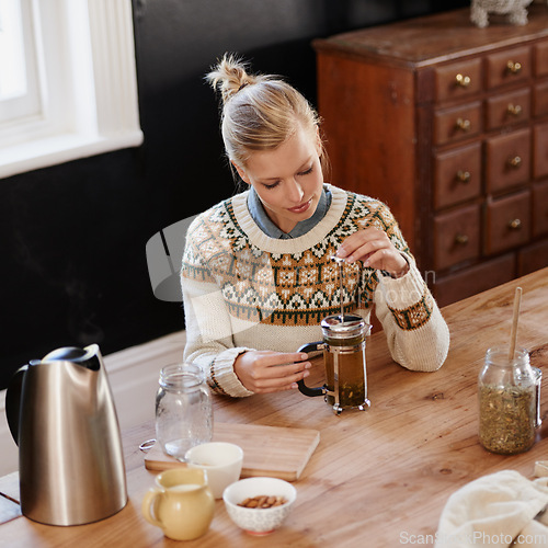 Image of Woman, happy and herbal tea for wellness in home and warm beverage of herbs mixture for health. Kitchen, lady and detox with dry leaves in plunger and chamomile drink to relax in apartment in above