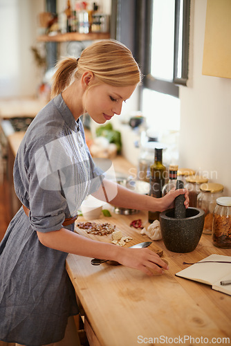 Image of Cooking, woman and mortar with grind in a home with diet, nutrition and healthy food with pestle. Kitchen, bowl and happy from organic and vegan lunch with mushroom and wood board with wellness