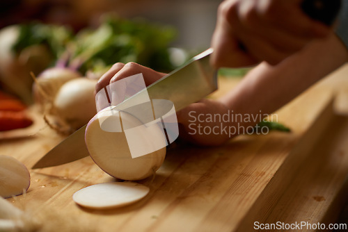 Image of Person, hands and turnip chop for salad with knife, wellness and health in a home for nutrition. Vegan, wood board and cooking with diet food in a kitchen with vegetable ingredients for lunch recipe