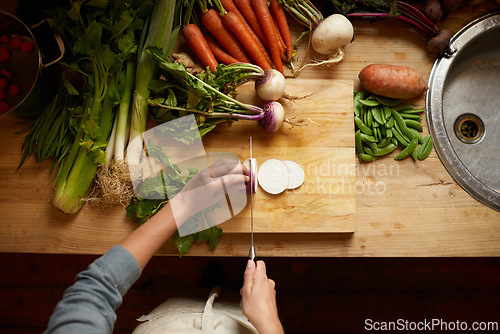 Image of Cutting, board and hands with vegetables for healthy food, cooking or preperation of soup ingredients on table. Chef or person above in kitchen with organic groceries and potato for a vegan dinner