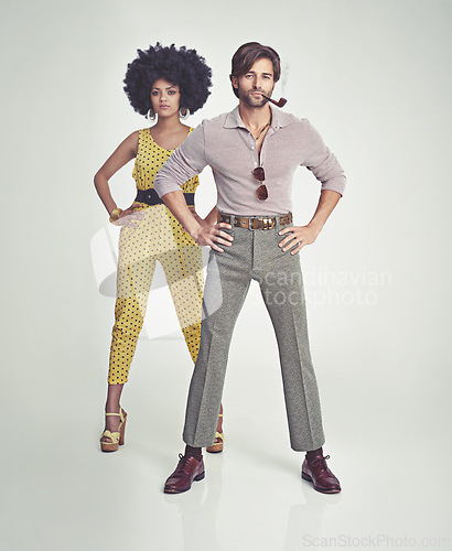 Image of Couple, portrait and fashion in confidence with pipe for smoking, style or outfit on a gray studio background. Interracial man, woman or smoker in stylish retro and vintage pants, shirt or jumpsuit