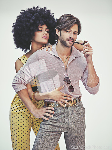 Image of Couple, portrait and fashion with pipe for smoking, style or outfit on a gray studio background. Young interracial man, woman or smoker in stylish pants, shirt or jumpsuit with jewelry or accessories