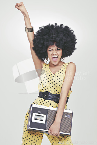 Image of Portrait, woman and fashion in studio with radio in jumpsuit, white background and fist with vintage content. Stylist, fancy and confident with old school look, trendy and exited with energy.