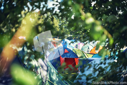 Image of Many tents, camping and outdoor in nature for a music festival. Row of rainbow marquees placed on ground at musical soiree, entertainment event and carnival celebration, relax on holiday campsite