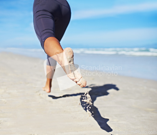 Image of Person, running and feet at beach with exercise, sport and training for marathon by the sea. Workout, fitness and back of a athlete with health and wellness outdoor of runner with cardio in summer