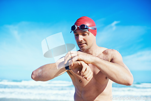 Image of Sea, swimming and time of a man with a watch for heart rate, wellness and fitness app for sport. Beach, athlete and ocean with clock and timer for marathon or race training in summer outdoor