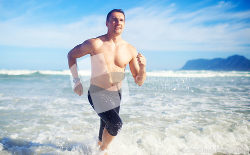 Image of Man, running and water by a beach with fitness, sport and training for marathon by the sea. Workout, exercise and back of a athlete with health and wellness outdoor of runner with cardio in summer