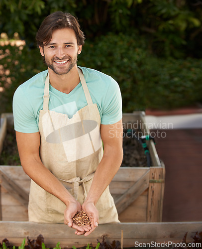 Image of Portrait, gardener and smile with seeds in hands for development, cultivation and growth in outdoor nursery. Man, happy and nature in garden for farming, nurture and future germination in plant shop