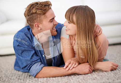 Image of Couple, hug and together on floor of living room with smile and affection, happiness or love for marriage. Lover, joy and faithfulness with care for time in home and romance to enjoy with person