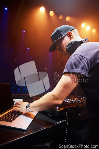 Image of DJ, man and laptop at nightclub for concert with spotlights, turntables and live music show. Professional person with crowd, playlists and mixing deck for party, rave or festival in Portugal