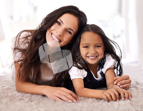 Image of Happy mother, portrait and child lying on floor in relax for bonding, love or care together at home. Face of mom, parent and little girl, daughter or kid with smile in living room for family time