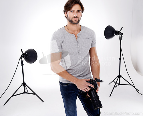 Image of Photographer, confidence or lighting with equipment in studio for career, behind the scenes or camera. Photography, guy and portrait with electronics, flash or shooting gear for photoshoot or passion