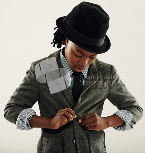 Image of Black child, suit and fashion in studio for vintage style and confidence on a white background. Retro kid or boy check his clothes, coat and fedora hat for fancy character, cosplay and formal