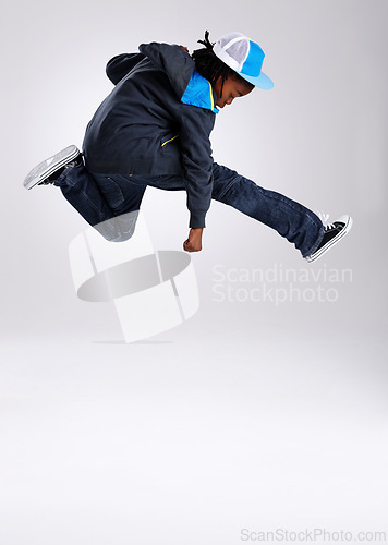 Image of Child, jump and dancing with hiphop and street style clothing in a studio with boy dancer. Trendy, energy and cool African kid with youth and rap music with white background and gen z clothes