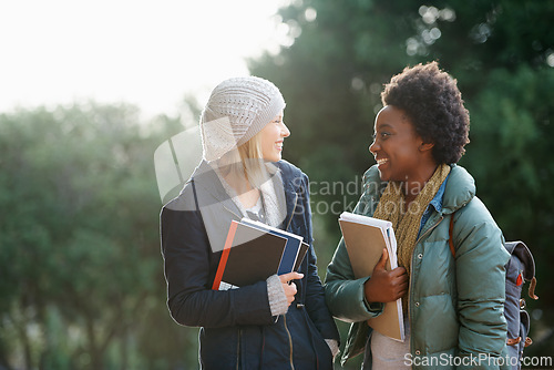 Image of Education, books and conversation with woman friends outdoor on campus together for learning or development. College, school or university with young student and best friend talking at recess break