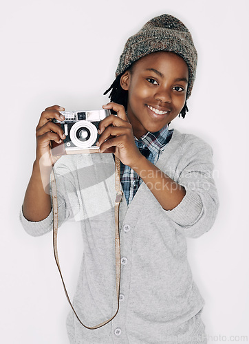 Image of Photographer, portrait or happy kid in studio with camera isolated on white background for creative talent. Photography, African boy or child artist with hobby, smile or picture ready for photoshoot