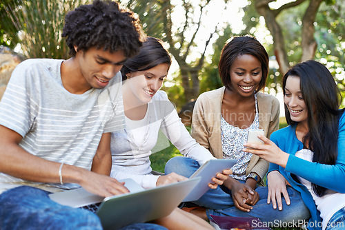 Image of Happy group, student and technology at park for collaboration, networking or communication. Young people or academic learners with smile on laptop, tablet and phone for online learning or education