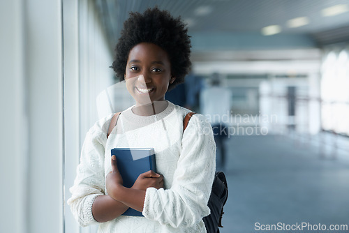 Image of African girl, portrait and hallway of college with smile from happiness of education in academy. Student, learning and notebook on hand with information for class in school campus and scholarship