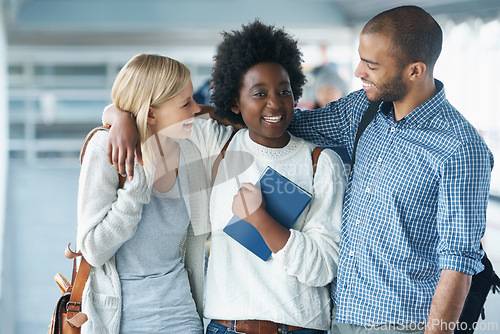 Image of Students, friends and hug in hallway at college with books for education, learning and knowledge. University, people and happy with backpack for break, relax or diversity with scholarship in corridor