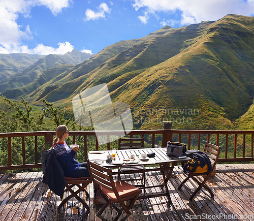 Image of Woman, nature and eating on a balcony for holiday, vacation and travel destination at a countryside hotel or lodge. Person with breakfast, food and thinking of mountains or view on eco friendly patio