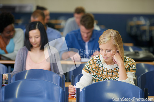 Image of University, class and students writing in lecture, hall and learning with notes on course or education. College, campus and people study for test in school and reading project, research or knowledge