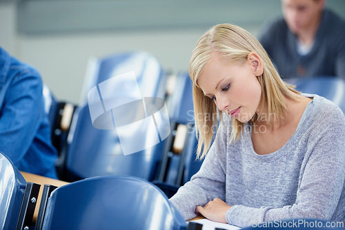 Image of Lecture hall, thinking and woman with knowledge, student or college with academy or education. Person, writing or girl in classroom with test or learning with studying or creativity with info or exam