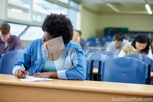 Image of Writing, college and black woman student in classroom studying for test, exam or assignment. Education, university and African female person working on project with knowledge in lecture hall.