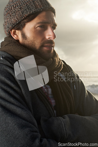Image of Man, nature and winter fashion by ocean for cold, comfort and protection in cape town weather climate. English guy, idea and trendy clothes of scarf, beanie and thinking at overcast beach in morning