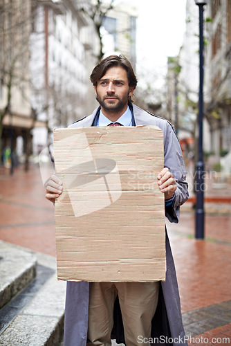 Image of Sad, business and man with poster, unemployed in city and professional with stress and anxiety. Person, outdoor and financial criss with worker and stock market crash with job loss with recession