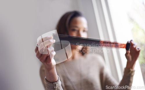 Image of Woman, photographer and film negative for creative prints at window for sun or retro images for job, inspiration or hobby. Female person, artistic and roll for picture development, photoshoot or job