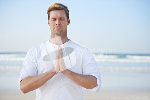 Image of Man, meditation on beach and prayer for zen, wellness and holistic healing outdoor for calm and yoga. Ocean, fresh air and travel with mindfulness for peace of mind, wellbeing and spiritual in nature