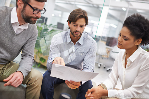 Image of Business people, documents and meeting in discussion for planning, brainstorming or finance at office. Young group of employees with paperwork in teamwork for budget and financial plan at workplace