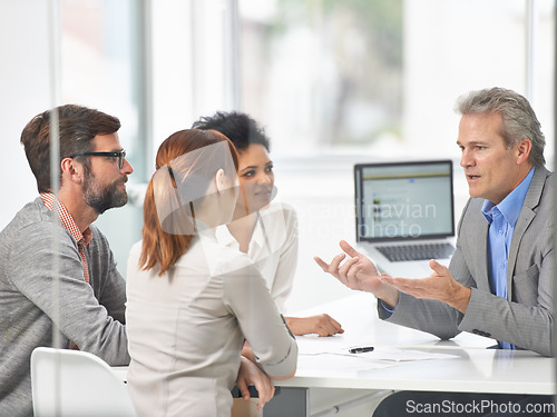 Image of Senior businessman, meeting and discussion with team in finance or coaching with documents at office. Man, CEO or executive talking to group of employees for financial growth or revenue at workplace