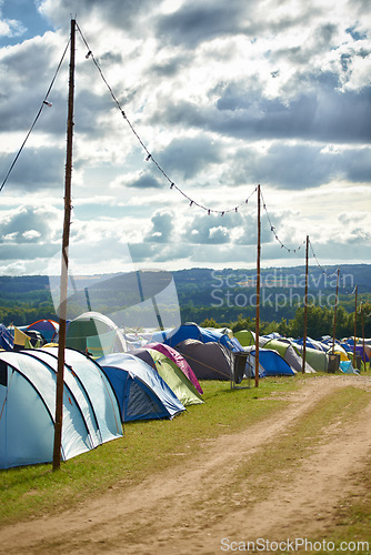 Image of Camping, tents and outdoor music festival in park for celebration on holiday vacation in summer. Campsite, background or shelter at party, event or travel in nature for concert or crowded carnival