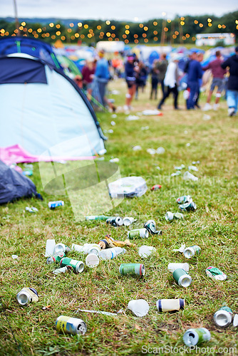 Image of Field, festival and litter with drinks, beer and beverage product for drinking a can in party. Concert outdoor pollution or alcohol on ground, grass or floor by trash or garbage with dirt or mess