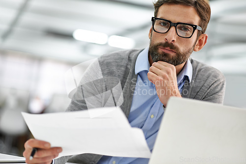 Image of Businessman, portrait and laptop with documents in finance, budget planning or investment at office. Man, accountant or employee with paperwork, financial report or policy by computer at workplace