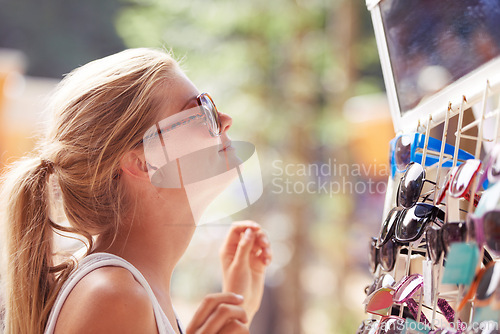 Image of Woman, buying sunglasses and shopping at market outdoor in summer with consumer at flea store. Sales, person and purchase shades at shop, decision and retail choice of customer trying eyewear gift