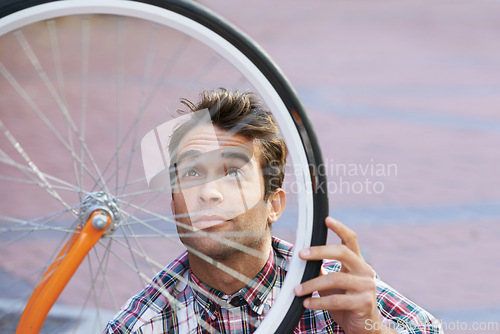 Image of City, check and man with bicycle wheel, sunshine and road with guy and transportation with sustainability. Bike inspection, person and hipster with maintenance and eco friendly with cycling and Italy