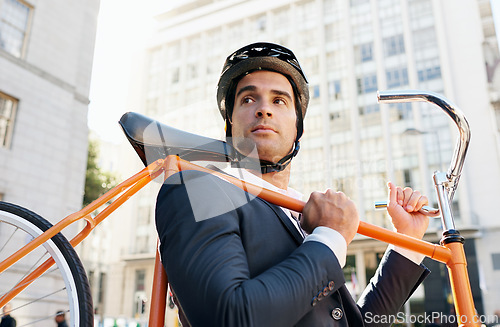 Image of Businessman, holding bicycle and helmet in city for travel, commute or journey to work in Chicago. Male person, buildings and road bike for sustainability, eco friendly and mobility in morning