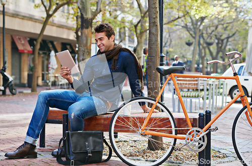 Image of Happy, city and smile with man, tablet and bicycle with adventure and digital app with email and social media. Person on bench, outdoor and New York with guy and technology with connection and typing