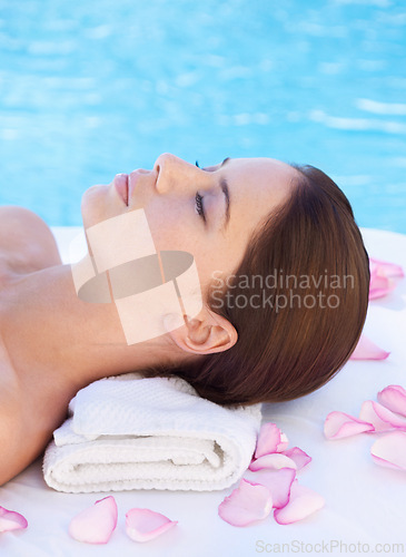 Image of Relax, massage and woman at luxury spa pool with petals for health, wellness balance and holistic treatment. Self care, peace and girl on poolside bed for body, comfort and calm hotel service