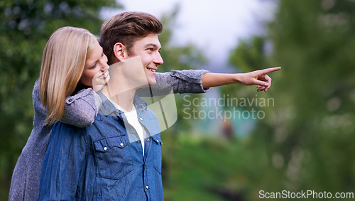 Image of Couple, smile and happiness with pointing finger in park, outdoor setting and bonding with activities. Relationship, goals and romance with fun day in forest for lifestyle, wellness and relax