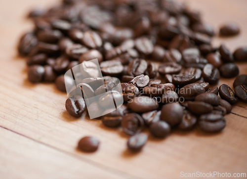 Image of Coffee beans, counter and espresso drink or caffeine preparation for beverage, cafe or cappuccino. Roasted, blend and ingredient for latte or restaurant barista for kitchen scent, breakfast or grind