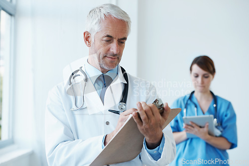 Image of Checklist, research or mature doctor writing medical notes, feedback review or schedule in hospital. Clipboard, healthcare paperwork update or man in clinic working on a science report or medicine