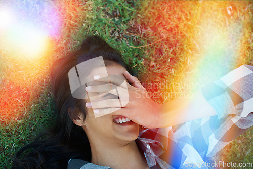 Image of Woman, relax and cover face on grass outdoor in summer with happiness on holiday or vacation. Girl, smile and hide with hand on lawn in garden or backyard in nature with sunshine or light leak