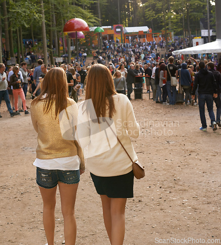 Image of Event, festival or party with woman friends walking outdoor on ground for concert with group of people. Nature, forest or woods with young girls on sand together in audience or crowd from back