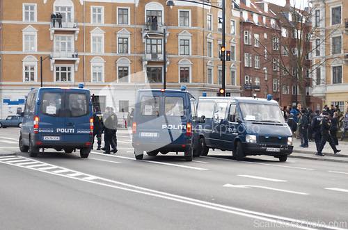 Image of Police, van and street with crowd, safety or protection service for public with justice in city. Vehicle, law enforcement and outdoor for danger, arrest and transportation on urban road in Copenhagen