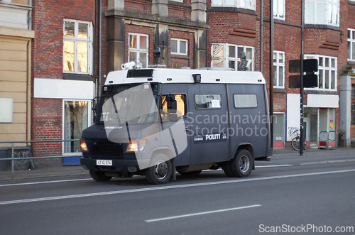 Image of Armored van, police and transport in street for safety, justice and patrol for protection in city. Vehicle, urban road and driving for public service to stop crime in metro by buildings in Copenhagen